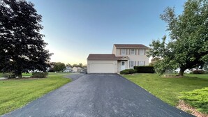 A residential driveway leading to a two-story house with a garage. - 3 bedroom house with fenced in yard and pool close to Syracuse (Cicero)