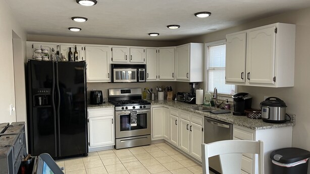 A modern kitchen with white cabinets, stainless steel appliances, and a granite countertop. - 3 bedroom house with fenced in yard and pool close to Syracuse (Cicero)