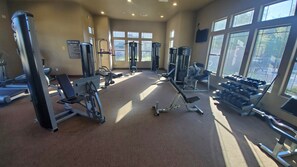 A gym with various exercise equipment, large windows, and a sign indicating it's the Rio Paseo Fitness Center. - 3Bed/3Bath GATED community CONDO w/ POOL,JACUZZI,FITNESS CENTER (Goodyear)