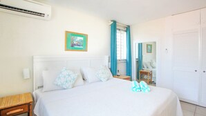 Ein Schlafzimmer mit Bett, Nachttisch, Spiegel und Kleiderschrank.