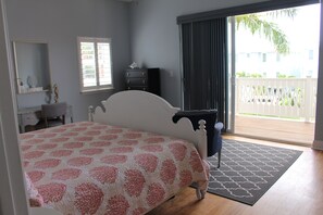 Quarto com cama, cômoda, escrivaninha e janela.
