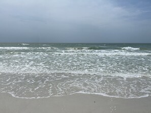 A beach with waves gently lapping at the shore.