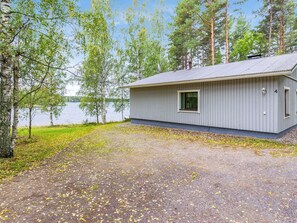 A cabin with a gravel driveway, a window, and a door.