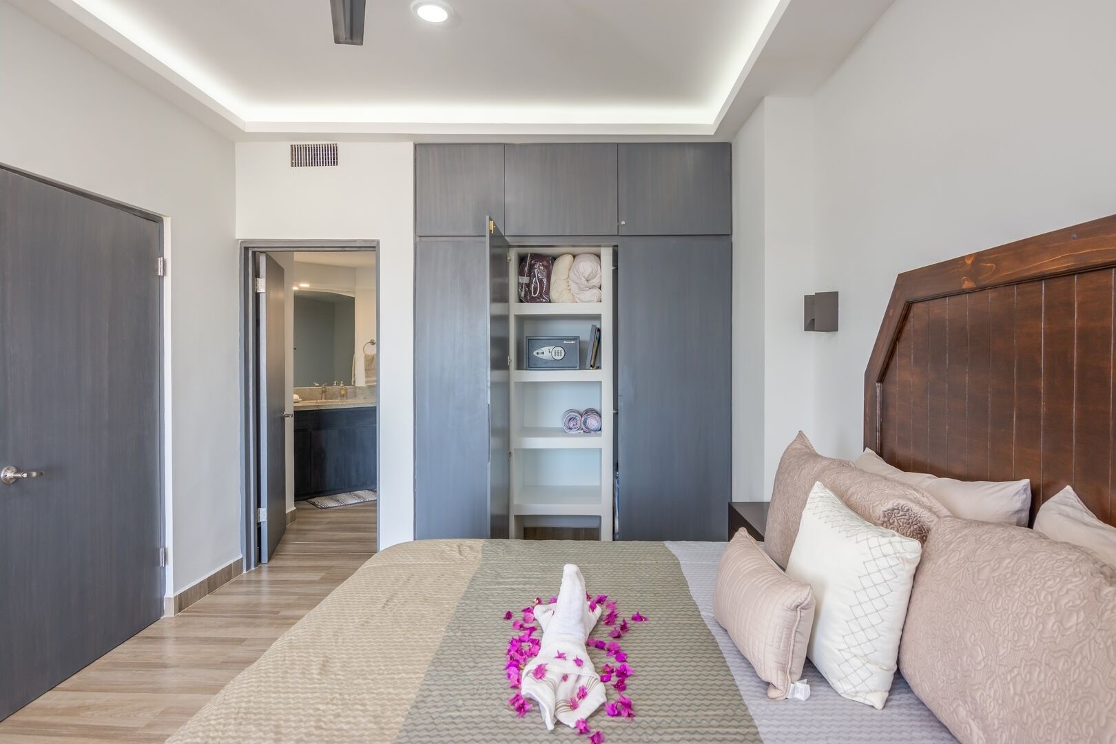 A bedroom with a bed, a wooden headboard, a wardrobe, and a built-in shelf unit.