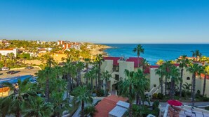 A coastal hotel with multiple-story buildings, a swimming pool, and palm trees. - AWESOME OCEAN VIEWS, GREAT LOCATION, PERFECT VACATION (Cabo San Lucas)
