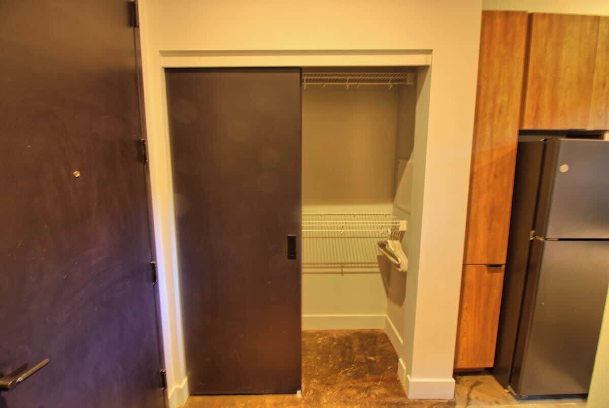 A kitchen with a refrigerator, a pantry, and a door leading to a closet.
