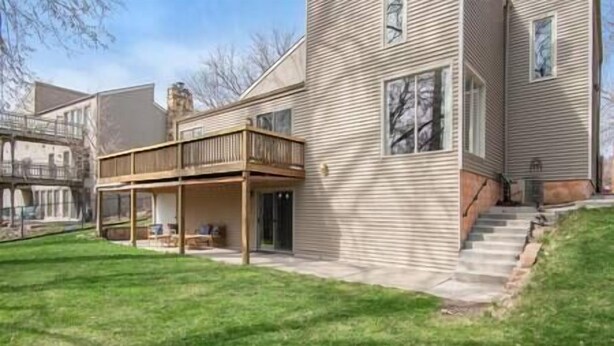 A two-story house with a covered patio and a small front yard. - Private Suite with Nature Views (Omaha)