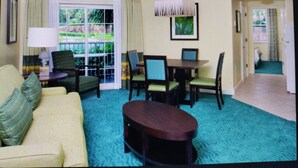 A living room with a sofa, chairs, a coffee table, a dining table with chairs, a ceiling fan, and a large window with curtains. - Spend your holiday in Paradise (Paradise Island)