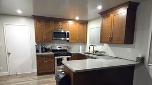 Una cocina moderna con armarios de madera, electrodomésticos de acero inoxidable y una isla grande.