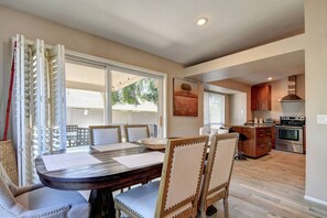 A dining area with a table, chairs, and a view of the kitchen.