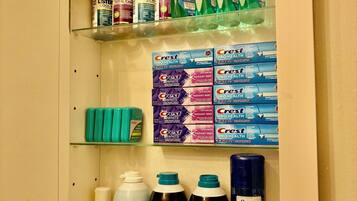 A bathroom cabinet with Crest Pro-Health toothpaste, Listerine mouthwash, Crest toothpaste, and Gillette shaving cream.
