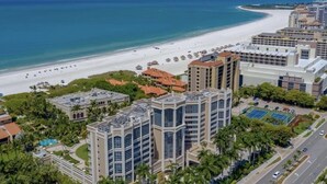 A coastal hotel with multiple buildings, a beach, and a road with vehicles. - Suite on the beach, classy, large private patio (Marco Island)
