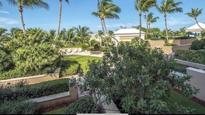 A resort with palm trees, a pool, and a building with a white roof. - Suite on the beach, classy, large private patio (Marco Island)