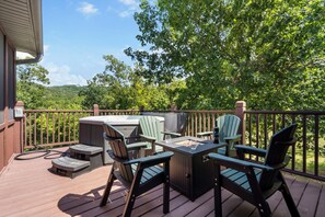 Une terrasse dotée de mobilier d’extérieur, d’un barbecue et d’un jacuzzi.