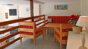 A room with a wooden bench, a sofa, a table, and a lamp.