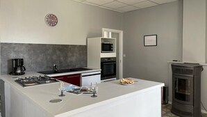 Eine moderne Küche mit Kochinsel, Mikrowelle, Backofen und Kachelofen.