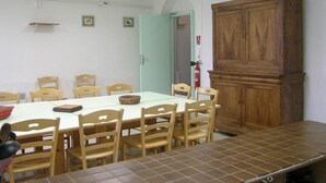 Un espace repas avec une longue table, des chaises en bois et un buffet.