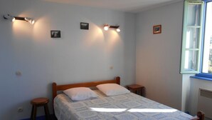 Une chambre à coucher avec un lit en bois, deux tables de chevet et une fenêtre donnant sur un beau paysage.