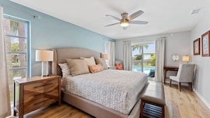 A bedroom with a bed, bedside tables, a desk, and a chair.