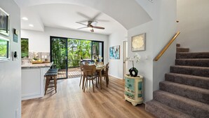 Una cocina amplia con comedor, piso de madera y una escalera.