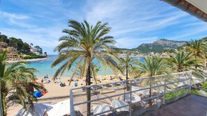 A beach view with palm trees, a pool area, and a mountain in the background. - LA Paleta- Casa EN Primera Linea DE LA Playa (Sóller)