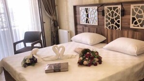 A hotel room with a large bed, a chair, an air conditioning unit, and decorative wall panels. - Yalova Sezon Hotel (Yalova)