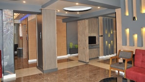 A modern lobby with a TV, seating area, and a reception desk. - Yalova Sezon Hotel (Yalova)
