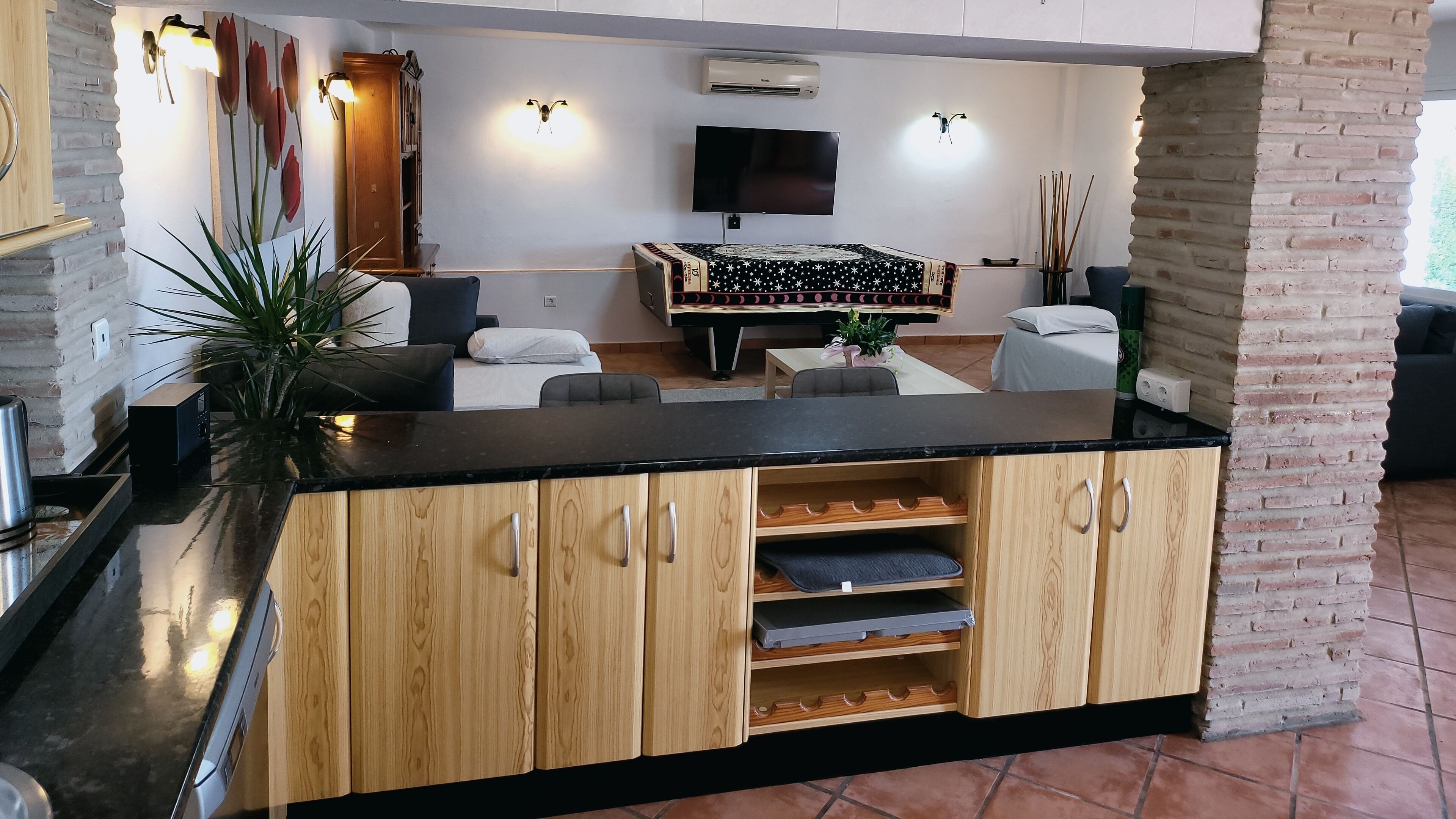 Una cocina moderna con armarios de madera, encimera negra y estufa integrada.