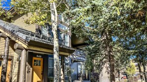 A two-story building with a wooden facade, a balcony, and a door marked with the number 840. - Pet-Friendly, Spacious, Views! Gas Grill, Washer/Dryer, Beautiful Location (Mammoth Lakes)