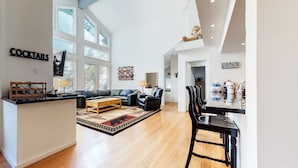 A spacious living area with a sofa, coffee table, and a kitchen area with a bar. - Pet-Friendly, Spacious, Views! Gas Grill, Washer/Dryer, Beautiful Location (Mammoth Lakes)
