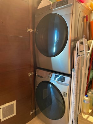 A laundry room with two stacked washing machines and a drying rack. - Ocean-view terrace, Pool & BBQ, Conchas Chinas (Puerto Vallarta)