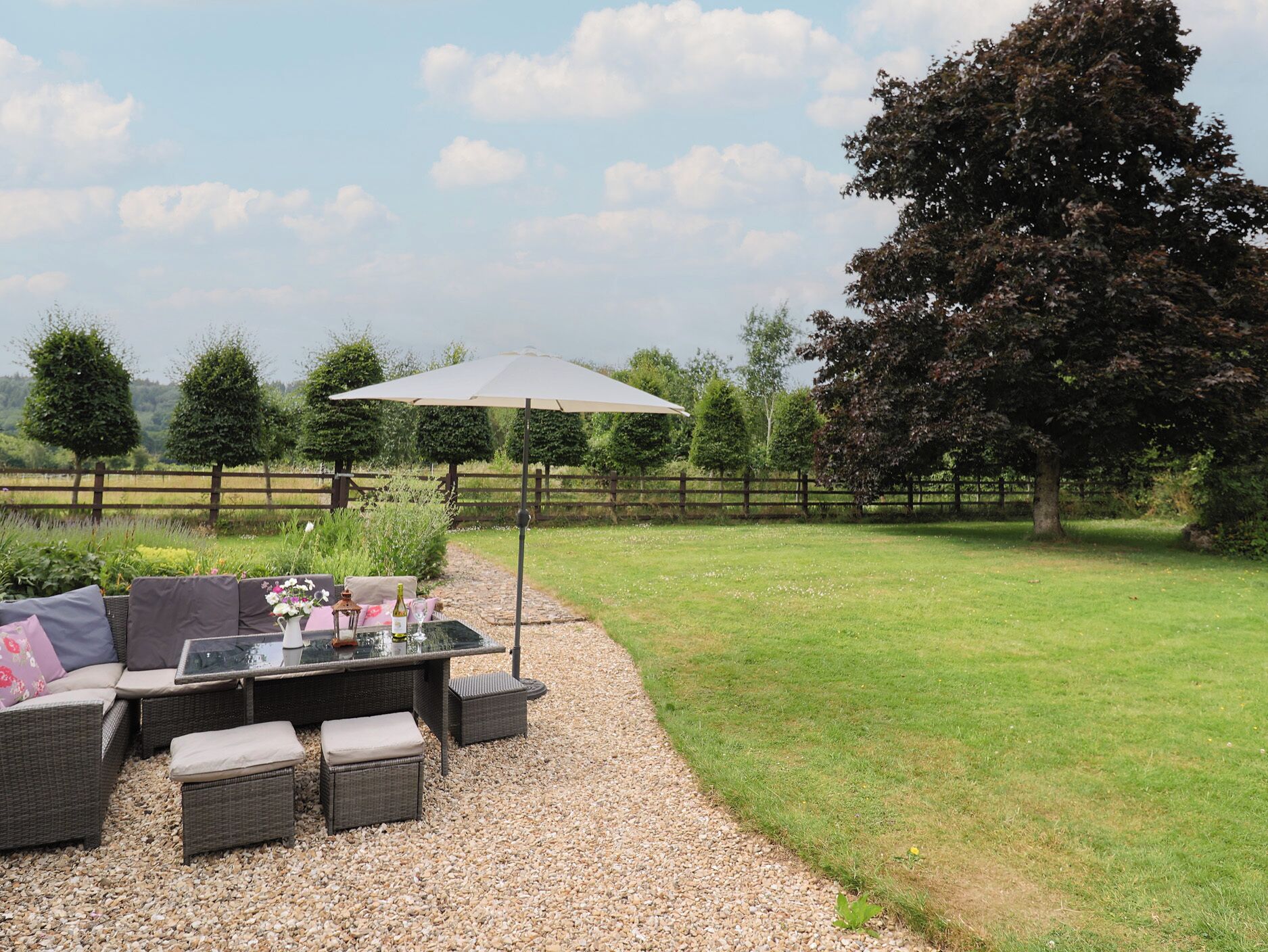 Un espace extérieur aménagé avec une table, des chaises et un grand parasol.