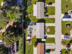 An aerial view of a residential area with houses, a road, and a green space with a playground. - Incredible Whole Condo with Heated Pool Next to Venice Island/Beach (Venice)