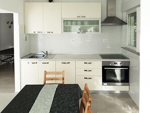 Enjoy cooking in this well-lit kitchen with a stainless steel sink, oven, and ample cabinetry.