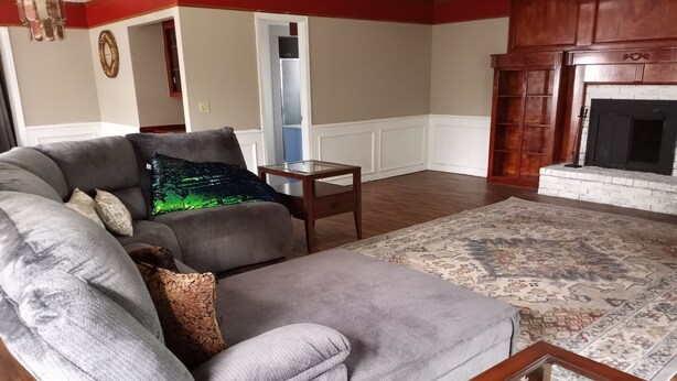A living room with a grey sofa, a small wooden table, and a patterned rug.