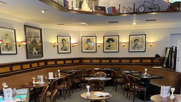A restaurant with wooden booths and tables, framed artwork on the walls, and a chandelier. - Peaky Blinder themed hotel rooms/studio apartments (Dudley)