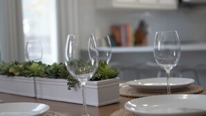 A dining table set with plates, glasses, and a centerpiece.