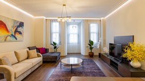 Ein modernes Wohnzimmer mit einer Couch, einem Couchtisch, einem Fernseher und Kunstwerken.