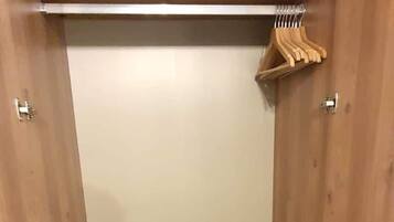Une armoire en bois avec deux étagères et une tringle pour suspendre les vêtements.