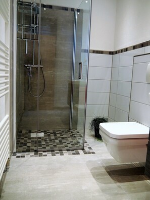 Een douche, een haardroger, badjassen, handdoeken