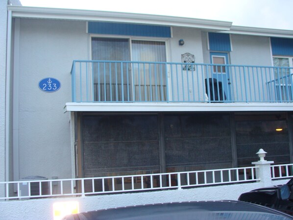 A two-story building with a blue balcony and a white railing.