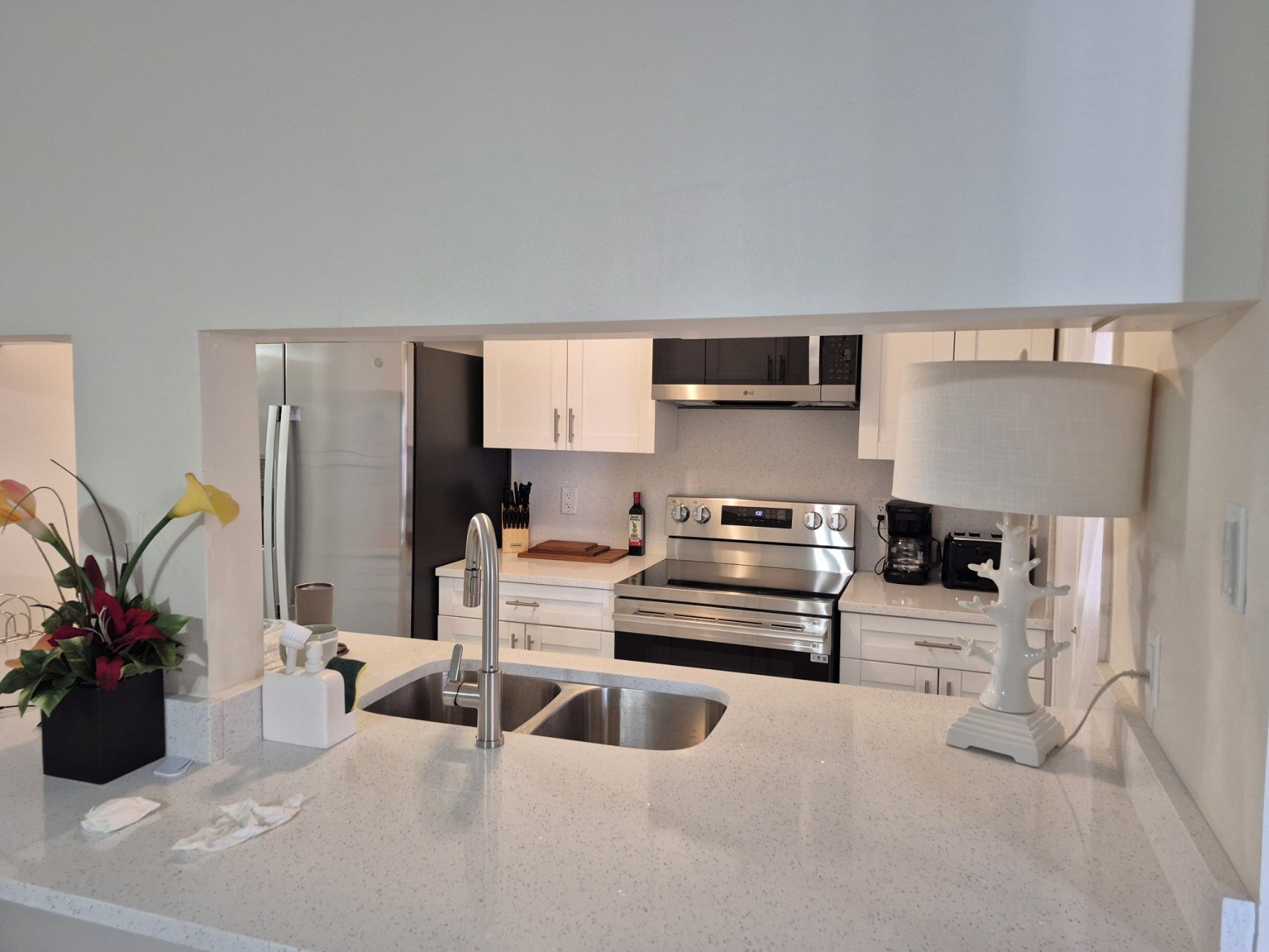 A modern kitchen with stainless steel appliances, a double sink, and a coffee maker.