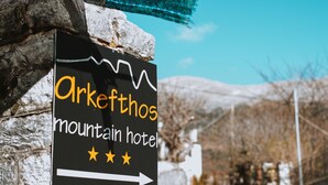 A sign for Arkephthos mountain hotel with a directional arrow and three stars. - Arkefthos Mountain Hotel (Zagori)