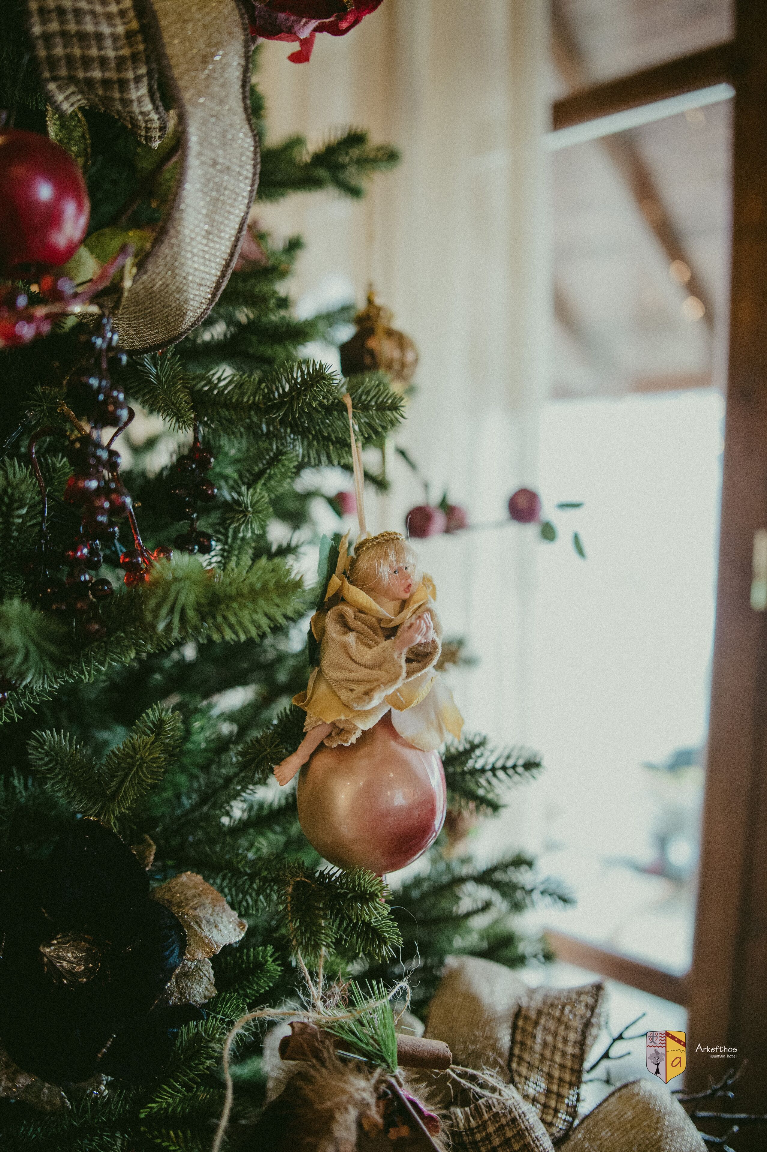 Un árbol de Navidad con adornos y un adorno envuelto en arpillera.