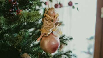 Un árbol de Navidad con adornos y un adorno envuelto en arpillera.