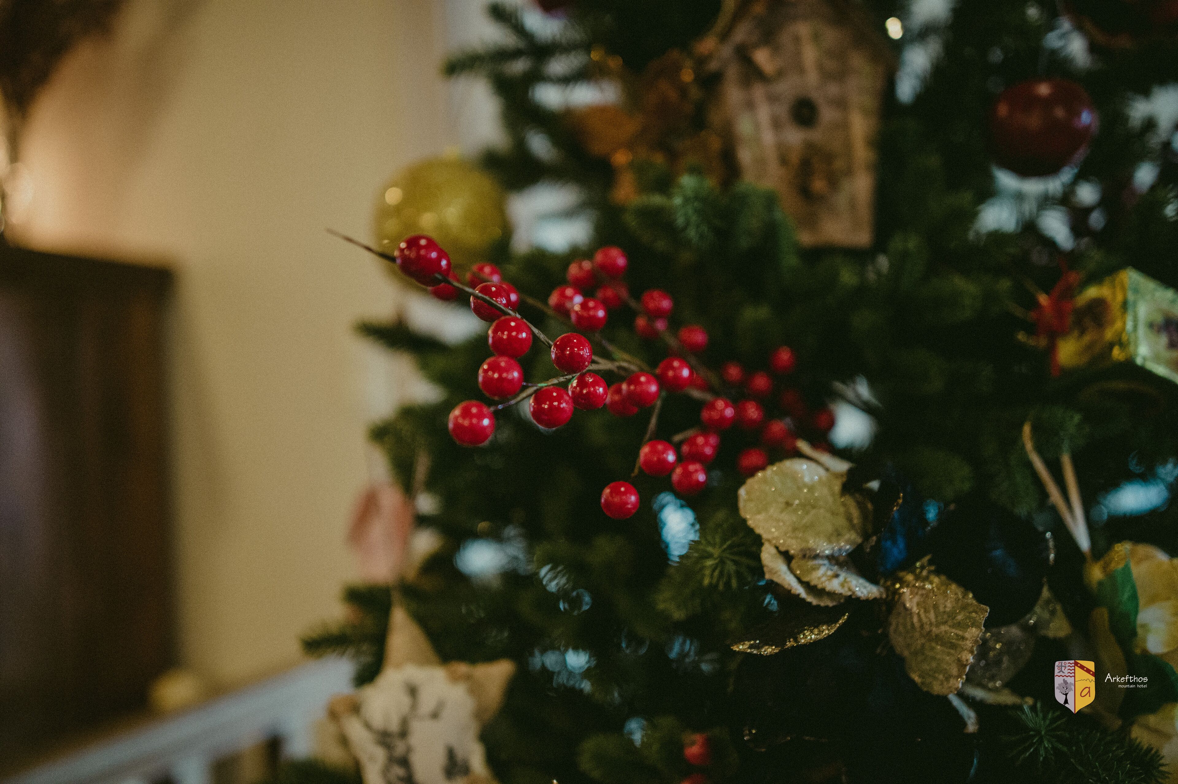 A Christmas tree with red berries and ornaments.