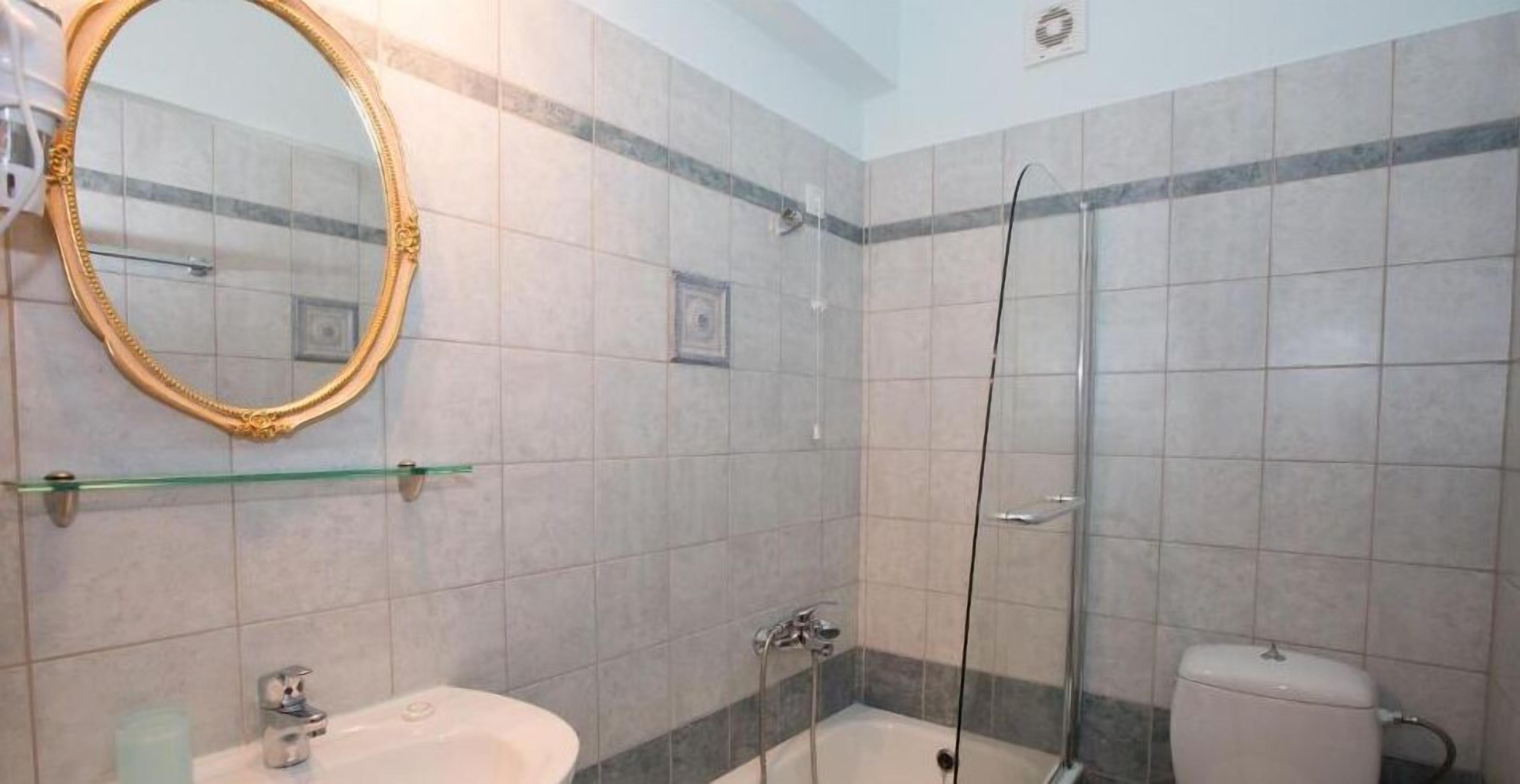 Un baño con lavabo, espejo y ducha.