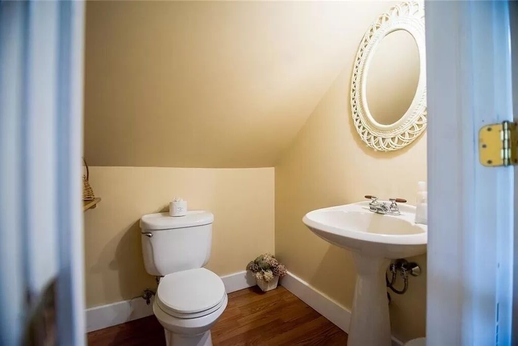 Une petite salle de bain avec des toilettes, un lavabo et un miroir.