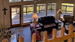 Un loft espacioso con ventanas amplias, un ventilador de techo y una zona de estar acogedora.