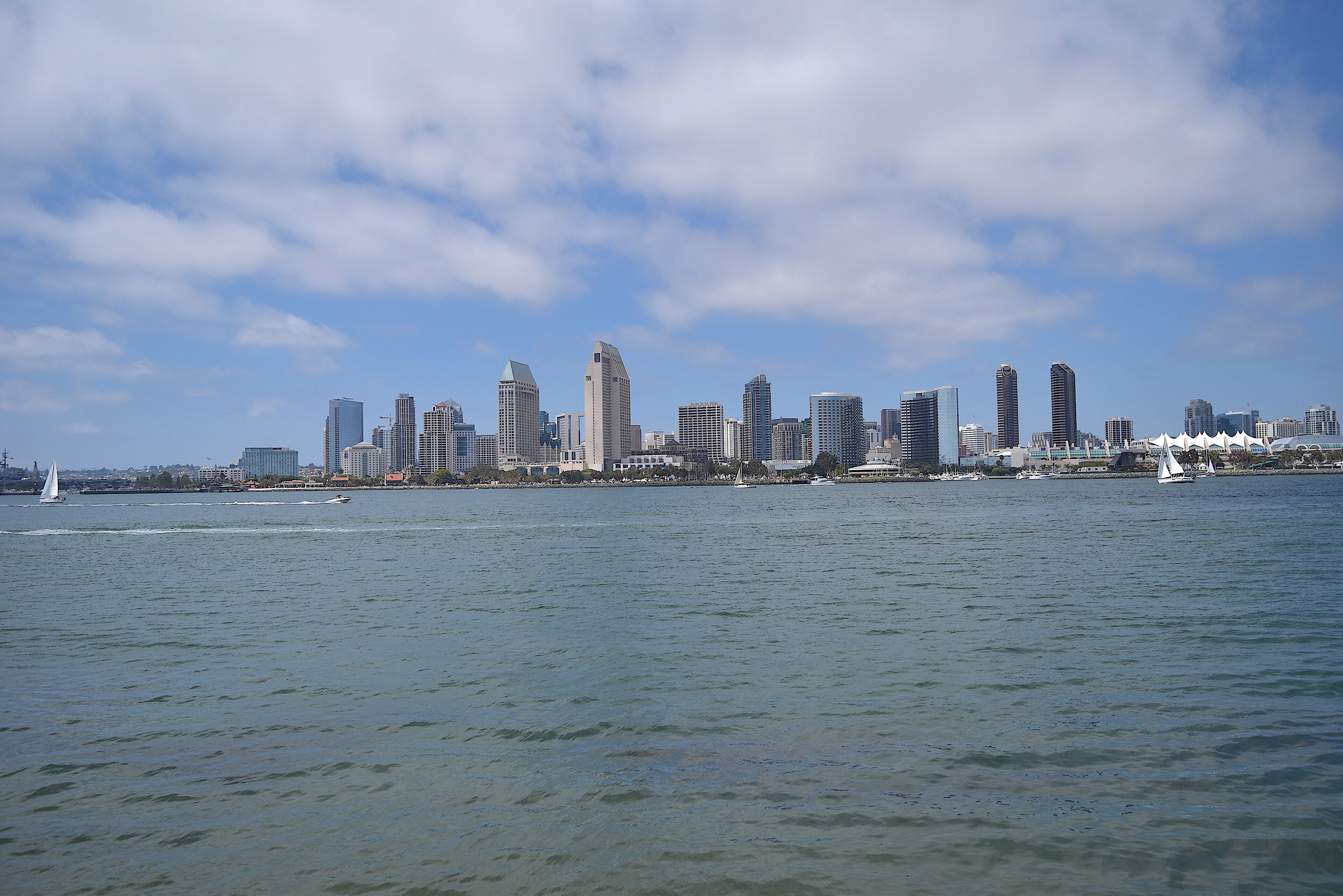 Eine moderne Skyline mit Hochhäusern über einem Gewässer.